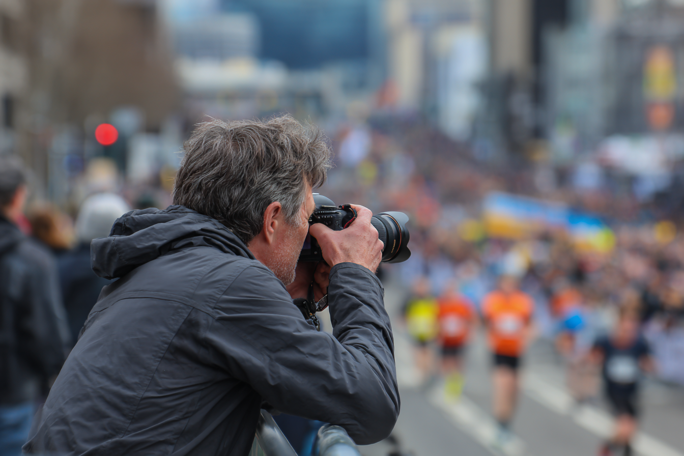 Fotógrafo deportivo en una carrera popular capturando imágenes de acción